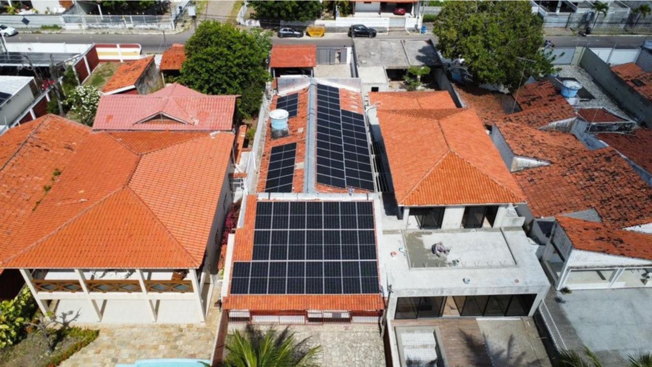 Sistema fotovoltaico de 34,7 kWp em telhado cerâmico residencial, vista de drone